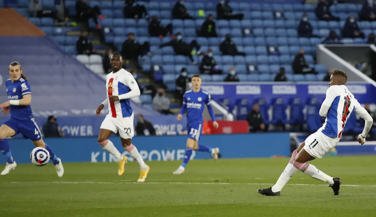 Striker Crystal Palace, Wilfried Zaha (kanan) melepaskan tendangan yang berbuah gol ke gawang Leicester City dalam laga lanjutan Liga Inggris 2020/2021 pekan ke-33 di King Power Stadium, Leicester, Senin (26/4/2021). Leicester menang 2-1 atas Crystal Palace. (AP/Andrew Boyers/Pool)