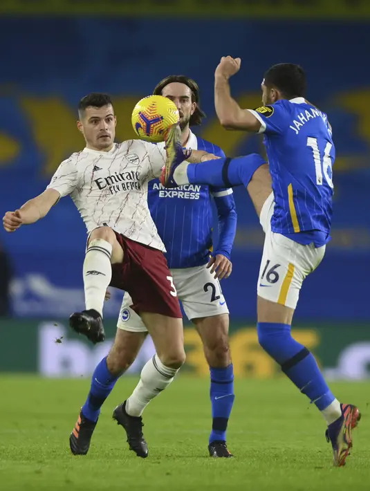 Gelandang Arsenal, Granit Xhaka berebut bola dengan penyerang Brighton & Hove Albion, Alireza Jahanbakhsh pada pertandingan lanjutan liga Inggris di stadion Falmer di Brighton, Inggris, Rabu (30/12/2020). Arsenal kini berada di posisi ke-13  klasemen. (Mike Hewitt/Pool via AP)