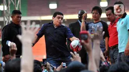 Legenda sepak bola Argentina Diego Maradona menendang bola untuk penggemarnya saat datang ke Stadion Gelora Bung Karno (GBK), Senayan, Jakarta, Sabtu (29/6/2013). Diego Maradona meninggal dunia pada 25 November 2020. (Liputan6.com/Helmi Fithriansyah)