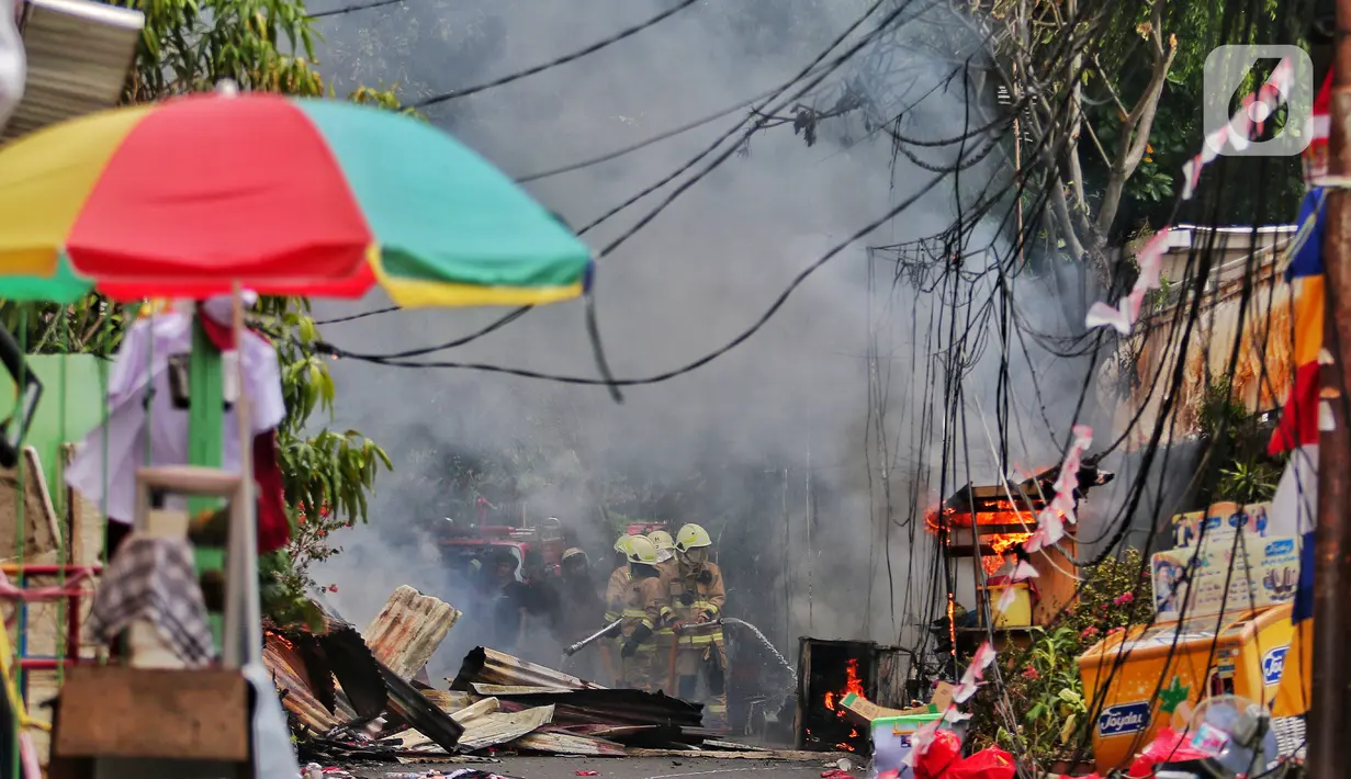 Petugas pemadam kebakaran berusaha memadamkan api saat terjadi kebakaran di kawasan padat penduduk di Jalan Simprug Golf II RT 4/8, Grogol Selatan, Kebayoran Lama, Jakarta Selatan, Minggu (21/8/2022). Belum diketahui penyebab kebakaran yang membakar puluhan rumah tersebut. (Liputan6.com/Angga Yuniar)