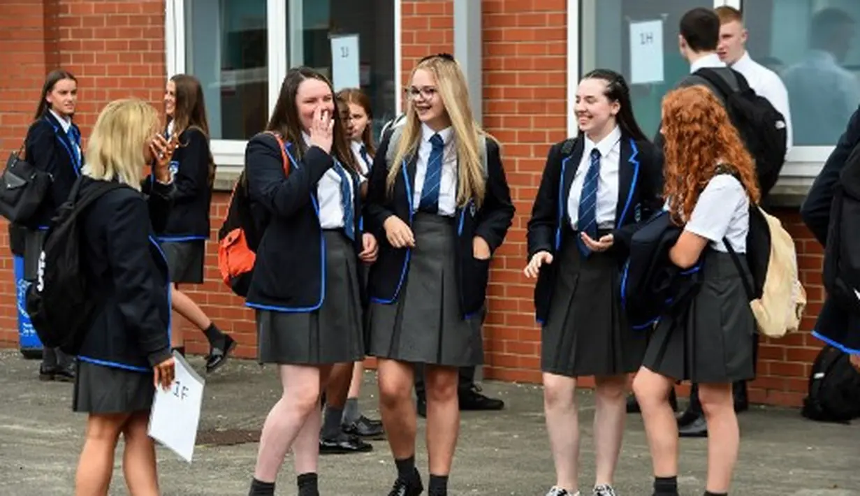 Antusiasme para pelajar Holyrood Secondary School saat kembali masuk sekolah di tengah pelonggaran lockdown di Glasgow, Skotlandia (12/8/2020).  (AFP/ANDY BUCHANAN)