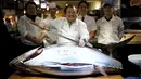 Pemilik restoran, Kiyoshi Kimura tersenyum sebelum memotong tuna sirip biru dengan berat 200 kg di depan restorannya, Tsukiji, Jepang, Selasa (5/1). Kimura mendapatkan tuna sirip biru dengan harga 14 juta yen atau Rp 1,6 miliar. (REUTERS/Toru Hanai)