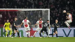 Gelandang Ajax, Antony (kanan) menyundul bola ke gawang Benfica saat pertandingan leg kedua babak 16 besar Liga Champions di Johan Cruyff ArenA di Amsterdam, Belanda, Rabu (16/3/2022). Benfica menang atas Ajax 1-0. (AP Photo/ Peter Dejong)