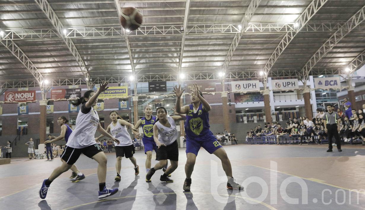 Pebasket Merpati Bali dan pebasket UPH berebut bola saat laga uji coba. Merpati Bali bakal berupaya untuk tampil dengan kekuatan berbeda dan terbaik pada turnamen di Pontianak. (Bola.com/M Iqbal Ichsan)