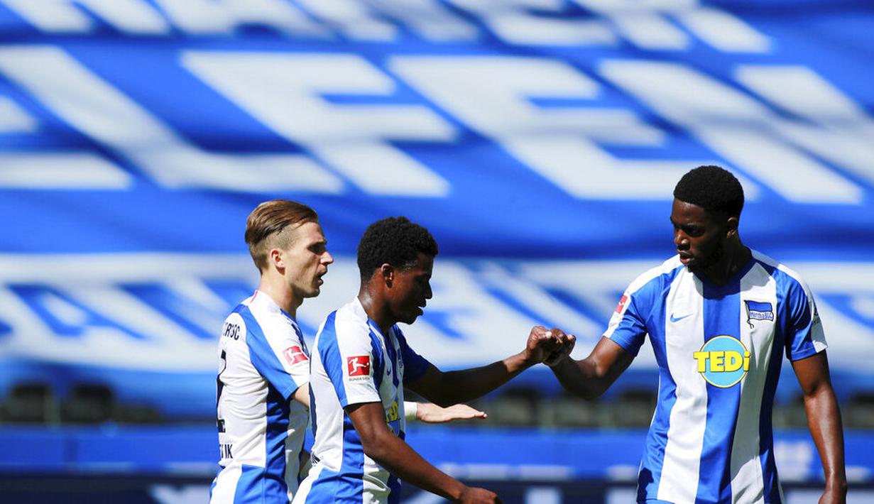 Para pemain Hertha Berlin merayakan gol yang dicetak oleh Javair Dilrosun ke gawang Augsburg pada laga Bundesliga di Olympiastadion, Sabtu (30/5/2020). Hertha Berlin menang 2-0 atas Augsburg. (AP/Hannibal Hanschke)