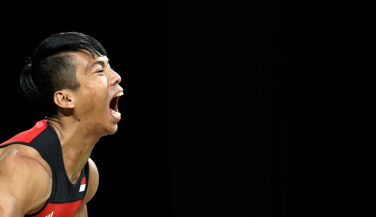 Ekspresi Deni, atlet angkat besi asal Indonesia saat berhasil melakukan angkatan di kelas 77kg Olimpiade 2016 Rio de Janeiro, Brasil, Rabu (10/8). Deni gagal menambah perolehan medali kontingen Indonesia di Olimpiade 2016. (REUTERS/Athit Perawongmetha)