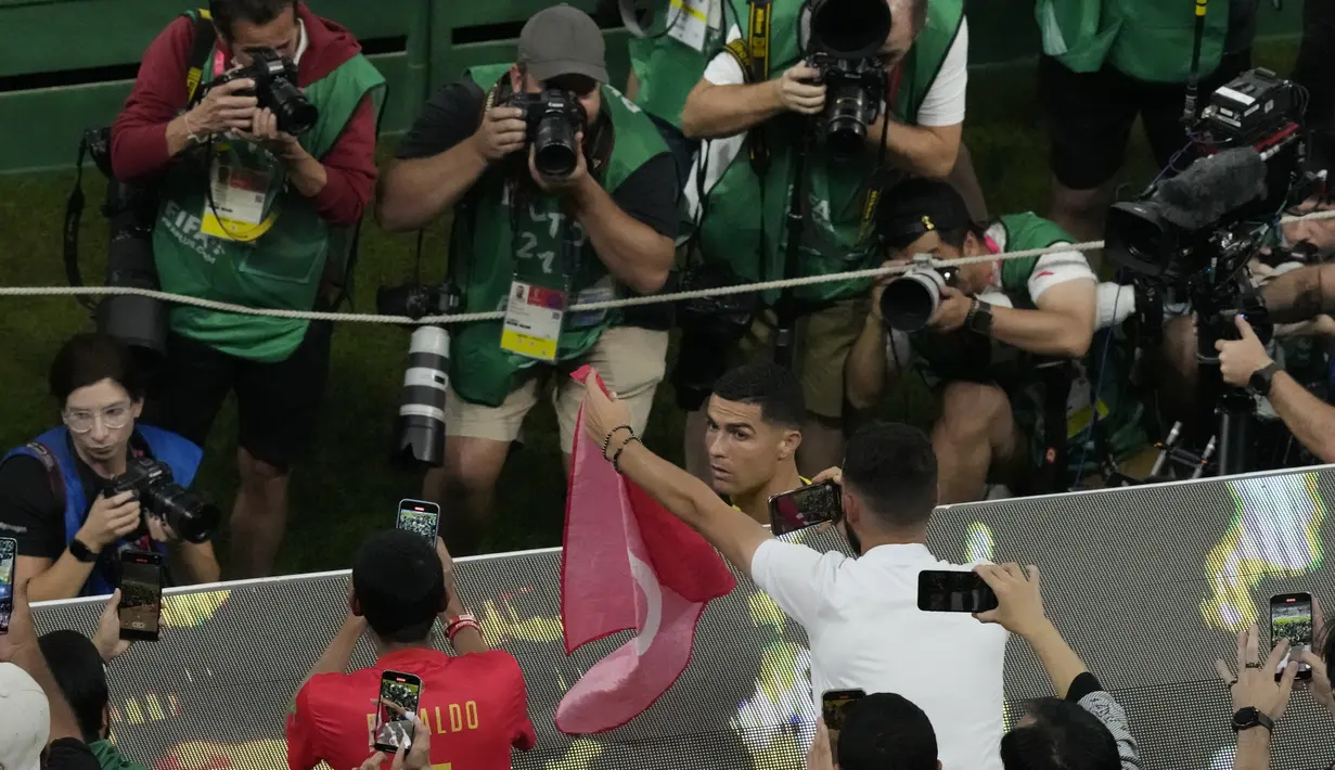 Penyerang Portugal, Cristiano Ronaldo berdiri di bangku cadangan sebelum pertandingan babak 16 besar Piala Dunia antara Portugal dan Swiss, di Stadion Lusail di Lusail, Qatar, Selasa (6/12/2022). Ronaldo mengawali laga dari bangku cadangan. Dia baru masuk menggantikan Joao Felix pada menit 73 ketika Portugal sudah unggul 5-1. (AP Photo/Frank Augstein)