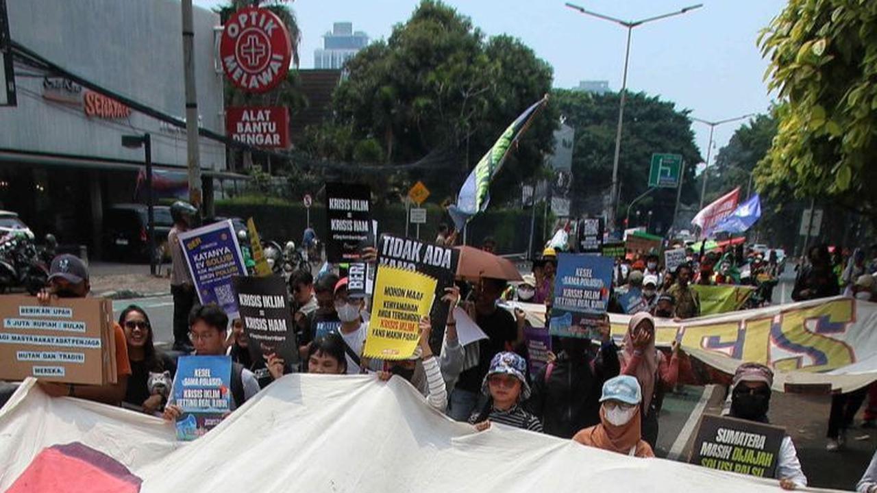 Mereka berjalan kaki sambil membentangkan poster unjuk rasanya dalam pawai Global Climate Strike yang berlangsung di Taman Menteng, Jakarta, Minggu (17/9/2023).