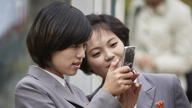 Dua siswa perempuan berseragam sekolah ini tampak sedang asyik menggunakan smartphone mewah di tempat umum (Sumber: Nextshark)