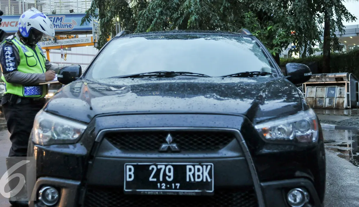 Petugas Kepolisian melakukan penilangan kepada pelanggar ganjil genap di Bundaran HI, Jakarta, Selasa (30/8). Sejumlah kendaraan masih didapati melanggar aturan ganjil genap yang telah resmi diberlakukan. (Liputan6.com/Yoppy Renato)