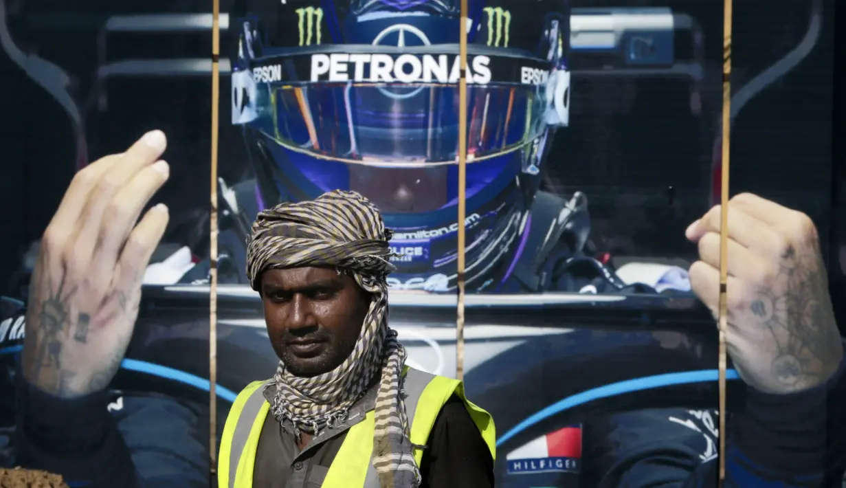 Seorang road crew bekerja di luar sirkuit corniche Formula One (F1), di Jeddah, Arab Saudi, Selasa (30/11/2021). Arab Saudi untuk pertama kalinya dipercaya menjadi tuan rumah balapan F1 2021, yang akan berlangsung 3-5 Desember mendatang. (AP Photo/Amr Nabil)