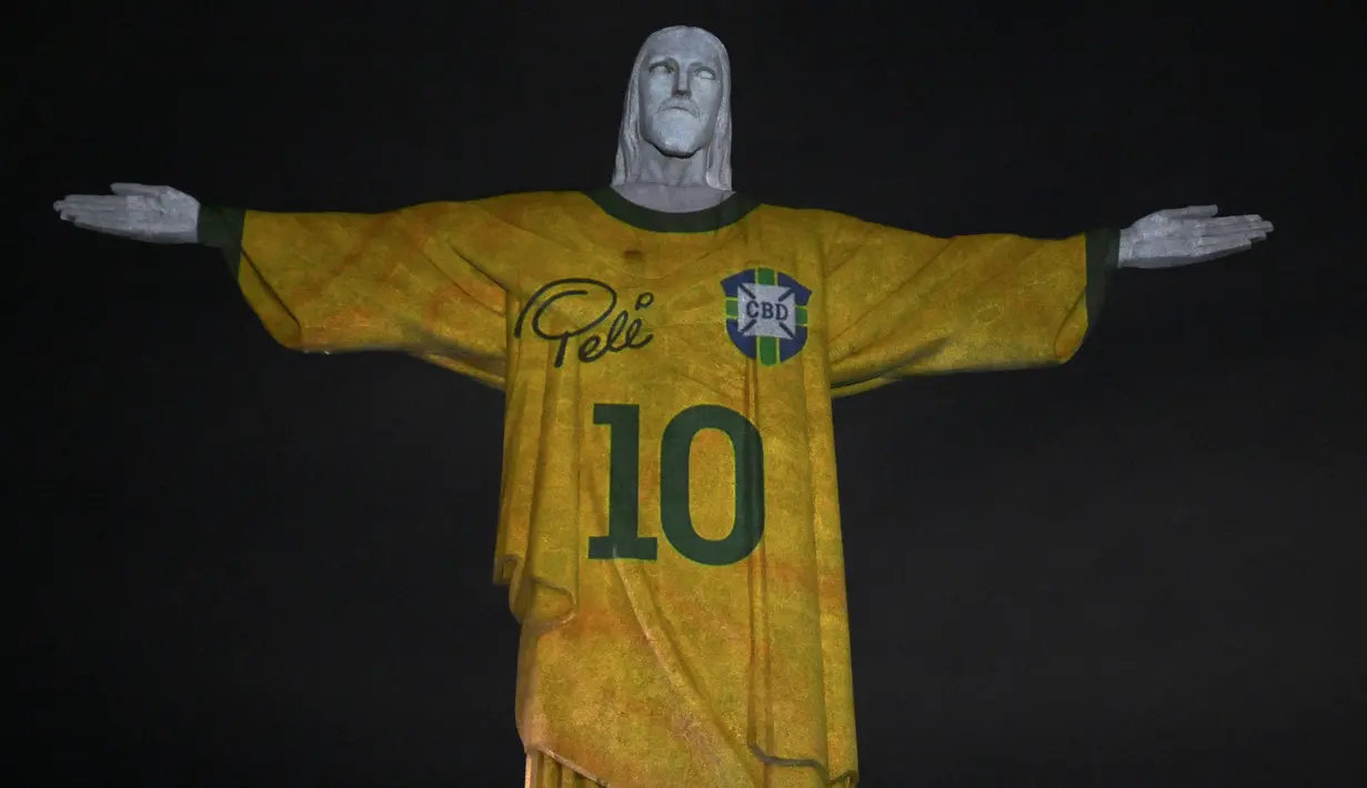 Sebuah gambar yang diproyeksikan ke patung Kristus Sang Penebus memberi penghormatan kepada legenda sepak bola Brasil Pele pada peringatan satu tahun kematiannya, di Gunung Corcovado di Rio de Janeiro, Brasil, Jumat (29/12/2023). (Mauro PIMENTEL / AFP)