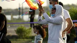 Seorang wanita saat menerbangkan layang-layang di festival layang-layang tahunan di Baghdad, Irak (5/6/2021). Festival layang-layang diadakan menarik ratusan penduduk setempat untuk menerbangkan layang-layang. (Xinhua/Khalil Dawood)