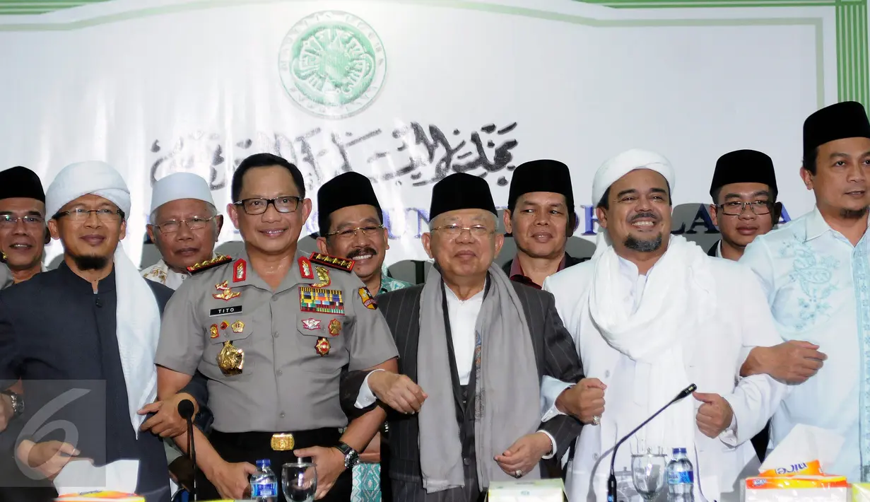 Kapolri Jenderal Pol Tito Karnavian (keempat kiri) bergandengan tangan usai memberi keterangan di gedung MUI, Jakarta, Senin (28/11). Kapolri dan GNPF MUI sepakat menyelenggarakan demonstrasi 2 Desember di Lapangan Monas. (Liputan6.com/Helmi Fithriansyah)