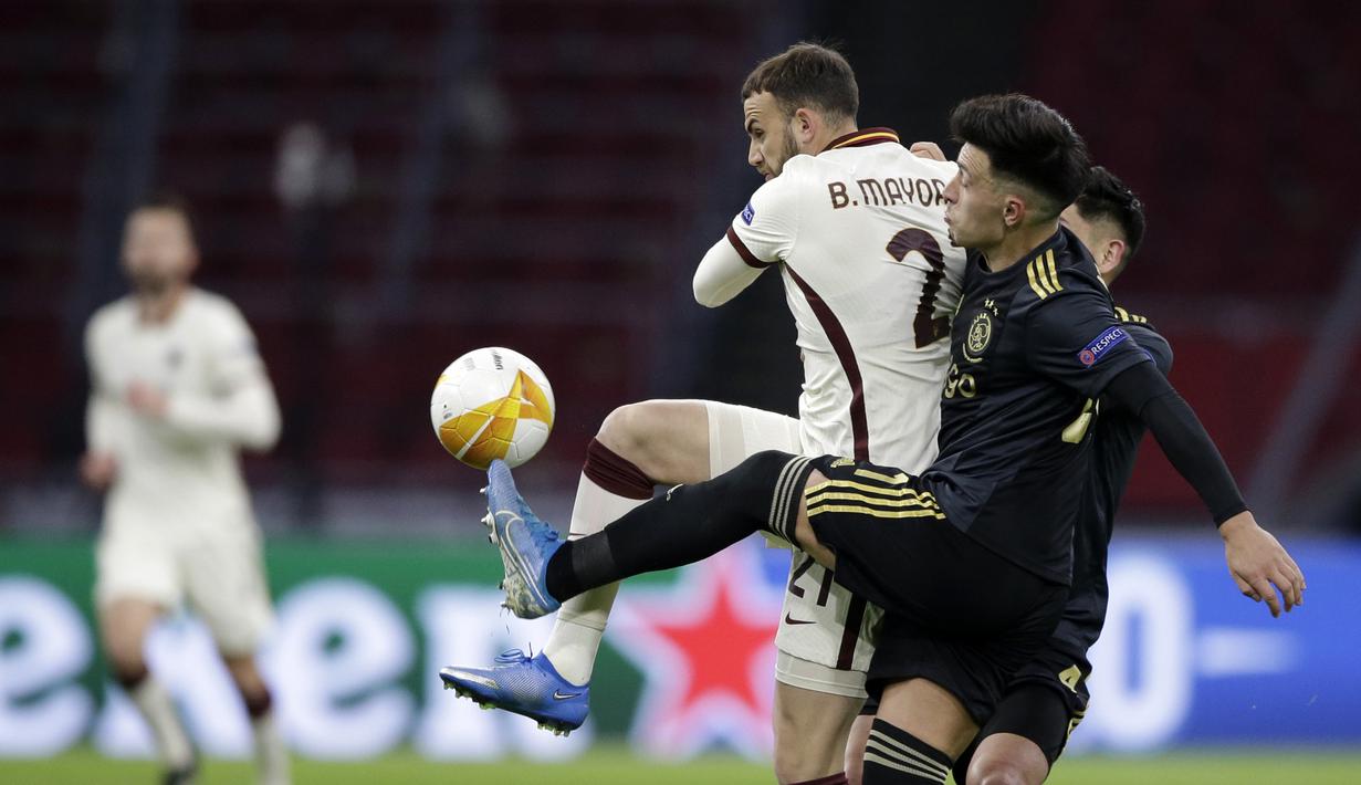 Striker AS Roma, Borja Mayoral (kiri) berebut bola dengan bek Ajax Amsterdam, Lisandro Martinez dalam laga leg pertama perempatfinal Liga Europa 2020/2021 di Johan Cruijff Arena, Amsterdam, Kamis (8/4/2021). AS Roma menang 2-1 atas Ajax. (AP/Peter Dejong)