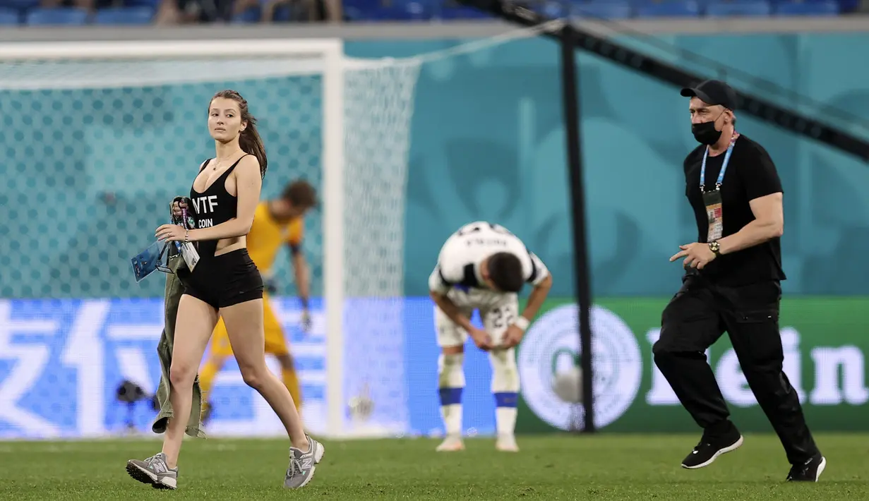 Sejumlah pihak keamanan sebenarnya telah berusaha mengejar wanita tersebut. Namun apa daya, wanita itu berlari dengan cepat dan berhasil mencapai tengah lapangan. (Foto: AP/Pool/Lars Baron)