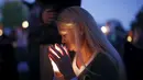 Seorang wanita membawa lilin saat melakukan aksi simpatik mengenang korban penembakan di Kampus Umpqua Community College di Roseburg, Sabtu (3/10/2015). Setidaknya 15 orang tewas dalam peristiwa tersebut. (REUTERS / Lucy Nicholson)