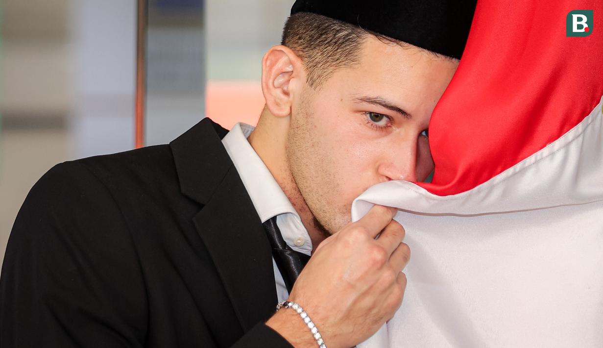 Pemain naturalisasi Indonesia, Justin Hubner mencium bendera merah putih setelah pengambilan sumpah WNI yang berlangsung di Kantor Wilayah Kementerian Hukum dan HAM (Kanwil Kemenkumham), Jakarta Timur, Rabu (06/12/2023). (Bola.com/Bagaskara Lazuardi)