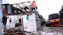 Sebuah KRL melintasi kawasan yang terkena pembongkaran di sekitar rel kereta api di kawasan Rawajati, Kalibata, Jakarta, Rabu (10/6/2015). Para warga rela membongkar sendiri rumahnya karena telah bermukim di lahan milik PT KAI. (Liputan6.com/Helmi Afandi)