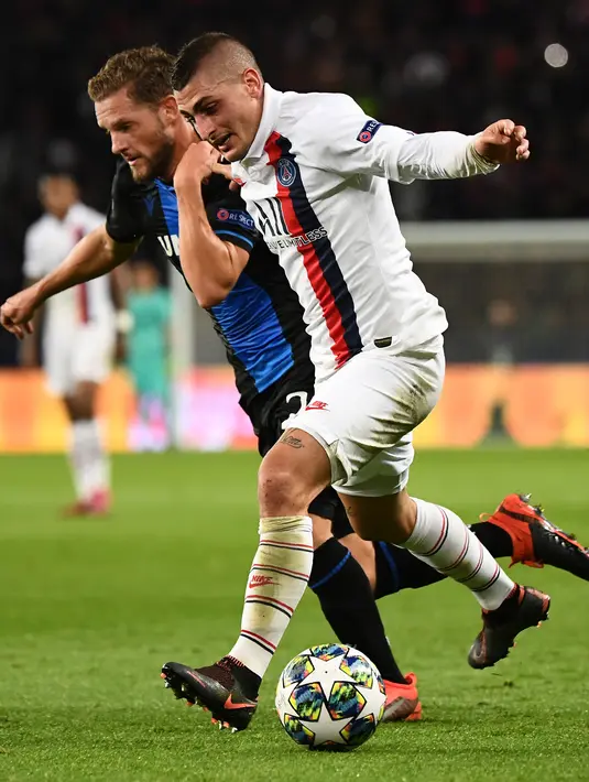 Gelandang Club Brugge, Mats Rits berusaha merebut bola yang dibawa gelandang Paris Saint-Germain, Marco Verratti  pada pertandingan Grup A Liga Champions di stadion Parc des Princes di Paris (6/11/2019). PSG menang 1-0 atas Club Brugge dan melaju ke babak 16 besar. (AFP Photo/Franck Fife)