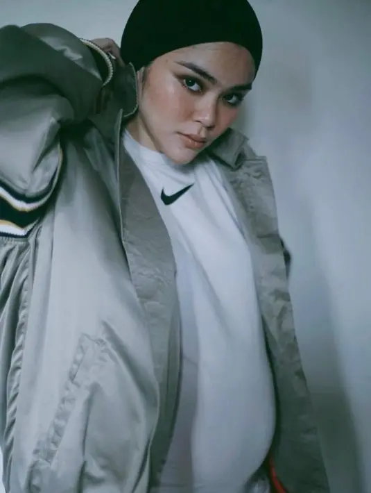 Ia memadukan t-shirt Nike putih dengan jaket abu-abu dan gaya hijab turban yang menjadi ciri khasnya. [@siviazizah].