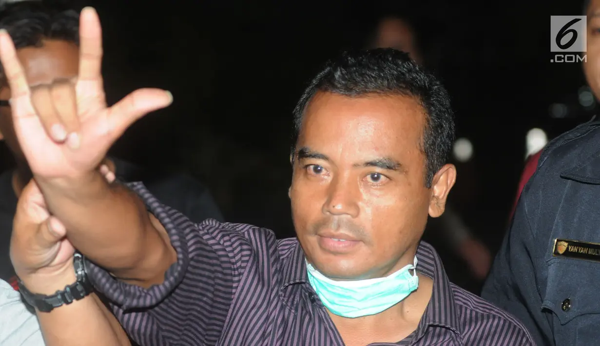 Bupati Purbalingga Tasdi mengacungkan salam saat tiba di Gedung KPK, Jakarta, Selasa (5/6). Tasdi terjaring Operasi Tangkap Tangan KPK bersama lima orang lainya yakni sejumlah pejabat daerah Purbalingga dan pihak swasta. (Merdeka.com/Dwi Narwoko)