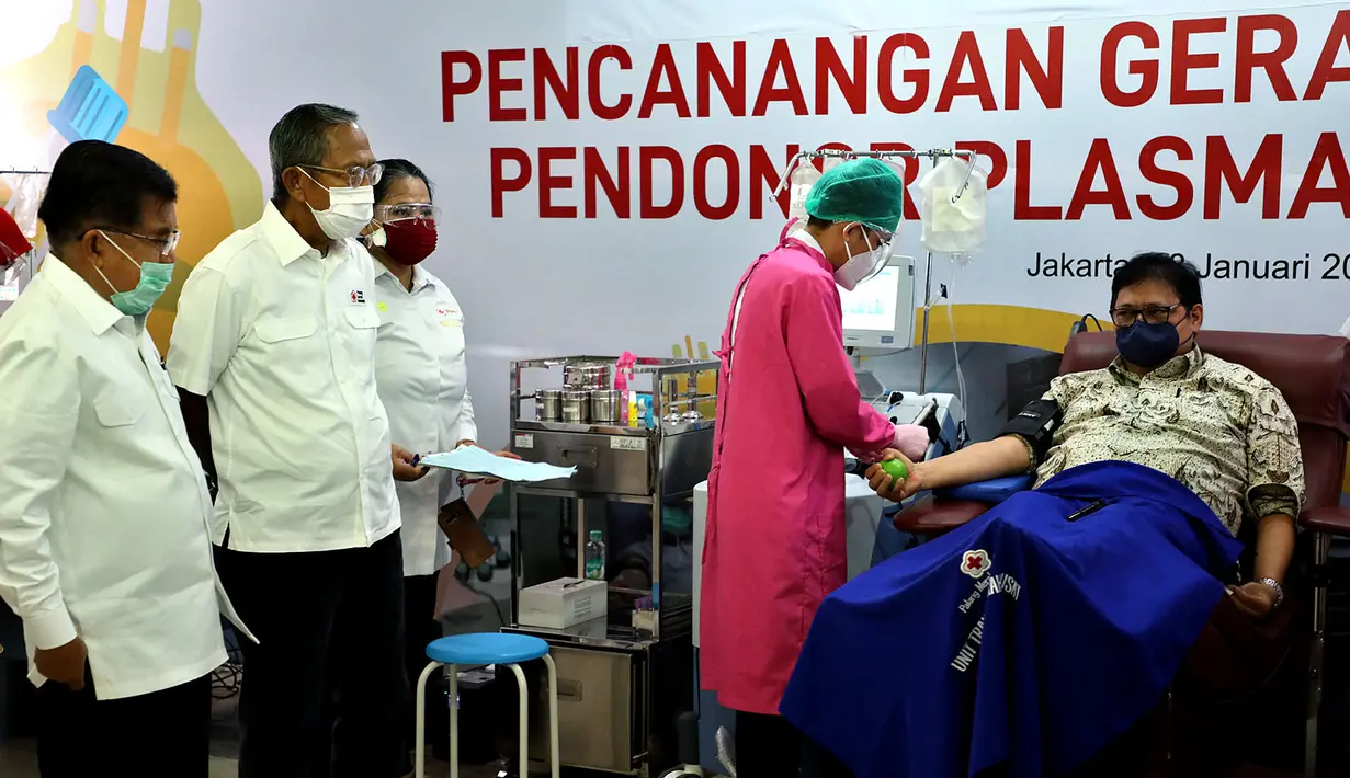 Ketua Umum PMI Jusuf Kalla (kiri) menyaksikan Menko Perekonomian Airlangga Hartarto (kanan) yang sedang melakukan donor plasma konvalesen saat Pencanangan Gerakan Nasional Pendonor Plasma Konvalesen di Markas PMI, Jakarta, Senin (18/1/2021). (StaffJK/Ade Danhur)