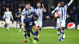 Pemain Real Sociedad, Igor Zubeldia, mengadang pemain Paris Saint-Germain, Kylian Mbappe, pada laga leg kedua babak 16 besar Liga Champions 2023/2024 di Stadion Reale Arena, Rabu (6/3/2024). Berkat hasil ini, PSG pun berhak melaju ke babak perempat final dengan kemenangan agregat 4-1. Pada laga leg pertama di Paris Februari lalu, PSG menang dengan skor 2-0. (AP Photo/Alvaro Barrientos)