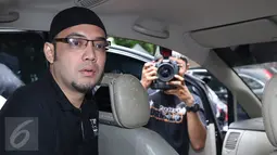 Sandy Tumiwa berada di mobil saat akan meninggalkan Kejaksaan Tinggi (Kejati) DKI Jakarta, Senin (7/11). Kedatangan Sandy untuk melakukan tahapan I, mengambil surat pengantar untuk dilimpahkan ke Kejaksaan Negeri Jakpus. (Liputan6.com/Herman Zakharia)