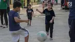 Anak-anak pencari suaka bermain sepak bola di halaman bekas Markas Kodim di Kalideres, Jakarta, Selasa (16/7/2019). Sebelumnya, para pencari suaka dari berbagai negara berkonfilk ini tinggal di pinggir jalan dan trotoar di kawasan Kebon Sirih, Jakarta. (Liputan6.com/Helmi Fithriansyah)