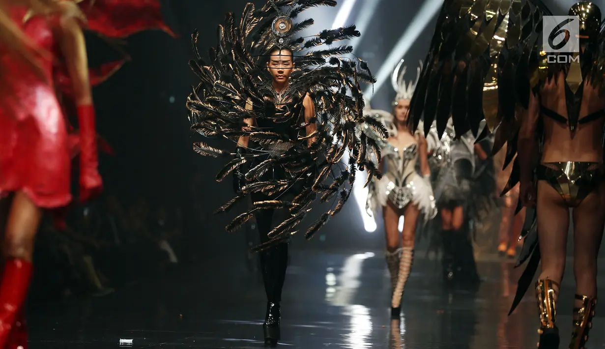 Model berjalan di catwalk mengenakan headpiece dan kostum karya Rinaldy A. Yunardi pada peragaan bertajuk 'Equilibrium' di Jakarta, Rabu (13/12). Unsur alam seperti air, api, angin, tanah, dan besi dituangkan dalam koleksinya. (Liputan6.com/Johan Tallo)