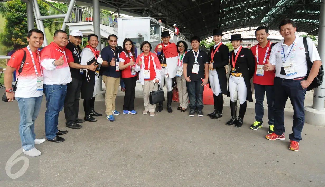 Tim berkuda Indonesia berfoto bersama dengan Ketua KOI, Rita Subowo (ketujuh kiri) usai meraih emas di nomor tunggang serasi tim Sea Games 2015 yang dihelat di Singapore Turf Club Riding Centre, Sabtu (6/6/2015). (Liputan6.com/Helmi Fithriansyah)