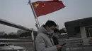 Warga yang menaiki feri berdiri di dekat bendera nasional China di Wuhan di provinsi Hubei, Jumat (15/1/2021). Selain masker, orang-orang menjalani kehidupan sehari-hari mereka seperti sebelumnya di Wuhan, tempat pertama kali virus corona COVID-19 terdeteksi. (AP Photo/Ng Han Guan)
