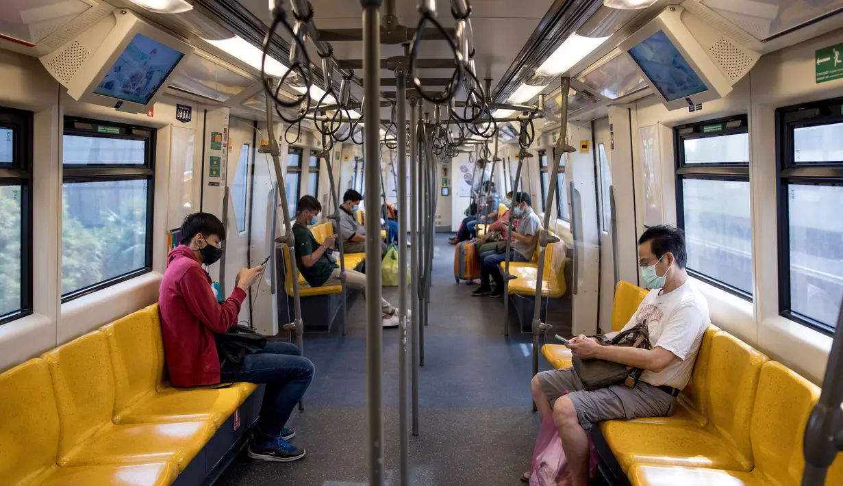 Para penumpang yang memakai masker memeriksa ponsel mereka di kereta layang atau BTS Skytrain di Bangkok, Thailand pada Senin (4/1/2021). Pejabat kesehatan di Thailand pada Senin mencatat 745 kasus virus corona baru, rekor tertinggi harian di negara itu sejak awal pandemi COVID-19. (Jack TAYLOR / AF