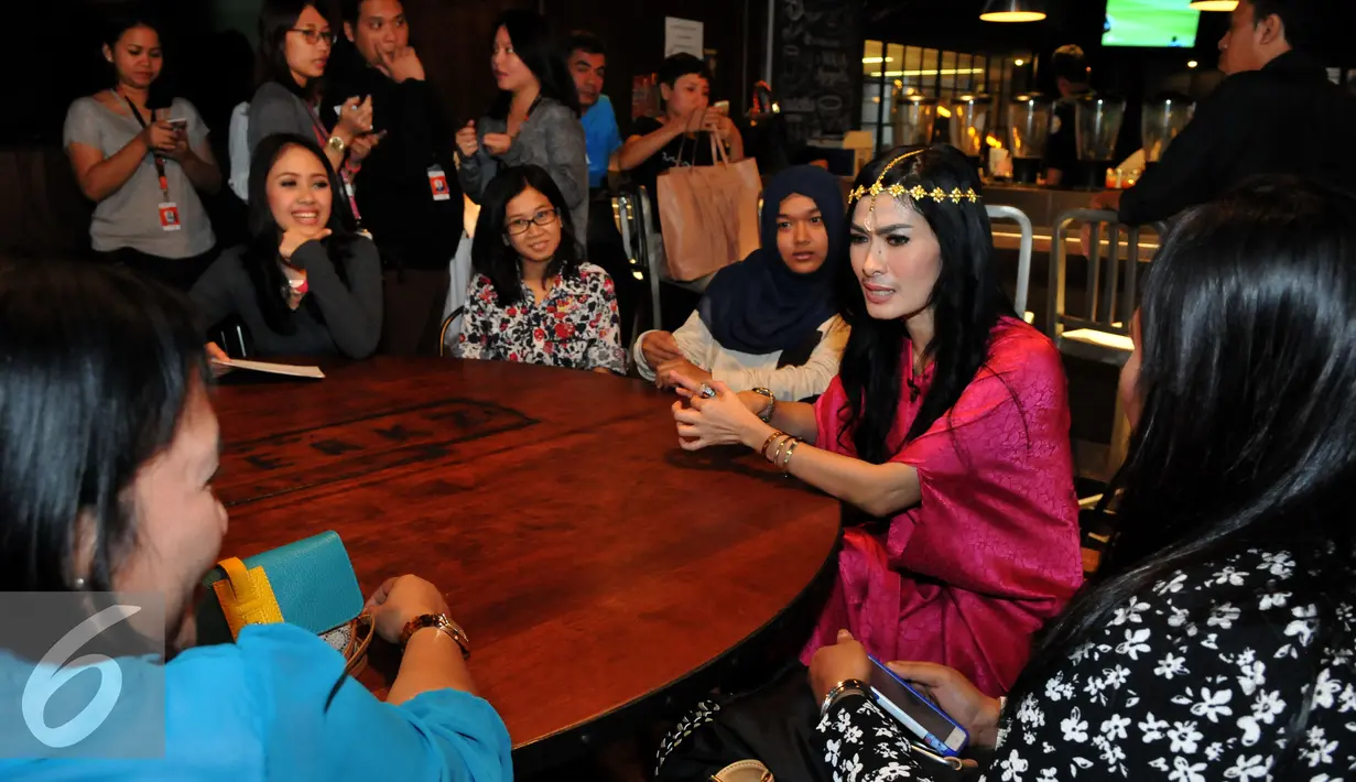 Iis Dahlia tampak berbincang dengan para fansnya saat berbuka puasa bersama di kawasan Senayan, Jakarta, Jumat (10/7/2015). Iis Dahlia tampil cantik dengan busana muslim berwarna pink. (Liputan6.com/Andrian M Tunay)
