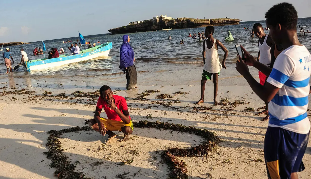 Seorang pria berpose di Pantai Jazera di pinggiran Mogadishu, Somalia (24/11). Pantai ini jadi tempat rekreasi populer bagi warga Somalia. (AFP Photo/Mohamed Abdiwahab)