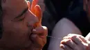 Seorang Imigran menjahit mulutnya selama lakukan protes kepada petugas yang menutup jalur perbatasan dari Yunani ke Gevgelija, , Makedonia, (23/11). Ratusan Imigran ini bersala dari Suriah , Irak dan Afghanistan.  (REUTERS/Ognen Teofilovski)