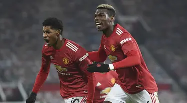 Penyerang Manchester United, Marcus Rashford (kiri) berselebrasi dengan rekannya Paul Pogba setelah mencetak gol pada menit 90+4 ke gawang Wolverhampton Wanderers pada pertandingan lanjutan Liga Inggris di Stadion Old Trafford, Rabu (30/12/2020). MU menang 1-0. (Michael Regan, Pool via AP)