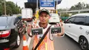 Petugas menunjukan kartu transaksi tol non tunai di gerbang tol Pejompongan, Jakarta, Jumat (15/9). Dalam menggunakan GTO ini, pengguna jalan tol diwajibkan memiliki kartu pembayaran non tunai sebagai kartu prabayar. (Liputan6.com/Angga Yuniar)