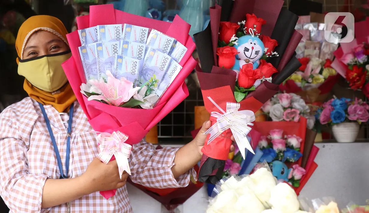 Penjual menujukkan bunga mawar yang dihias dengan boneka,uang dan coklat di Rawa Belong, Jakarta, Senin (14/2/2022). Hari Valentine yang diperingati setiap 14 Februari menjadi berkah bagi para penjual bunga karena banyak pesanan bunga di momen kasih sayang tersebut. (Liputan6.com/Angga Yuniar)