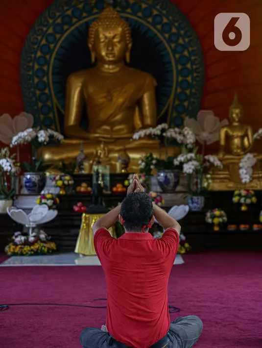 Seorang umat Buddha melakukan ibadah Hari Raya Tri Suci Waisak di Vihara Jakarta Dhammacakka Jaya, Rabu (26/5/2021). Pelaksanaan upacara Trisuci Waisak 2565/2021 dirayakan oleh umat Buddha secara terbatas dengan menerapkan protokol kesehatan secara ketat. (Liputan6.com/Faizal Fanani)