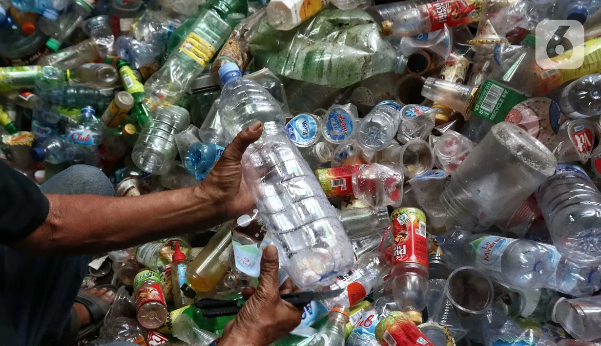 Bahkan terkadang Bu Wati juga ikut mencari botol plastik bekas berkeliling perumahan yang nantinya akan dijual di lapak pak Karno. (Liputan6.com/Angga Yuniar)