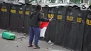 Pengunjuk rasa membawa bendera Merah Putih saat terlibat bentrok dengan polisi di Jalan Medan Merdeka Timur, Jakarta, Kamis (8/10/2020). Bentrokan terjadi akibat massa yang memaksa masuk ke depan Istana Negara untuk berunjuk rasa terkait penolakan UU Cipta Kerja. (Liputan6.com/Immanuel Antonius)