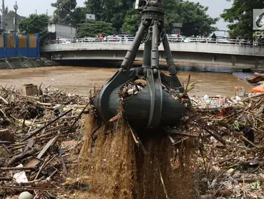 Alat berat mengangkat sampah yang menumpuk di Pintu Air Manggarai, Jakarta, Jumat (26/4). Sampah yang didominasi potongan bambu dan botol plastik kembali memenuhi Pintu Air Manggarai akibat curah hujan yang tinggi di kawasan Bogor dan sekitarnya, Kamis (25/4). (Liputan6.com/Helmi Fithriansyah)