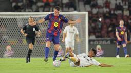 Pemain Barcelona Legends, Javier Soriano berebut bola dengan pemain DRX World Legends, Maman Abdurrahman dalam laga Clash of Legends di Stadion Utama Gelora Bung Karno (SUGBK), Senayan, Jakarta, Sabtu (18/04/2026). (Bola.com/Bagaskara Lazuardi)