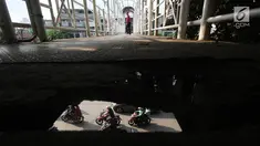 Pejalan kaki melintasi Jembatan Penyeberangan Orang (JPO) dengan kondisi bolong, berkarat dan tanpa atap di Petamburan, Tanah Abang, Jakarta, Selasa (24/10). Kondisi jembatan ini cukup mengganggu kenyamanan pejalan kaki. (Liputan6.com/Immanuel Antonius)