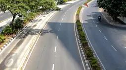Pengendara motor melintasi jalan protokol di kawasan Kuningan, Jakarta, Kamis (16/7/2015). H-1 jelang Lebaran, situasi Ibukota Jakarta sudah sepi ditinggal warganya yang mudik ke kampung halaman. (Liputan6.com/Faizal Fanani)