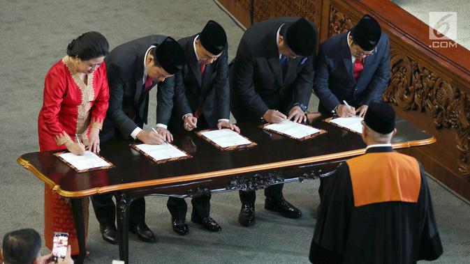 Puan Maharani (kiri), Aziz Syamsuddin, Sufmi Dasco Ahmad, Rachmat Gobel dan Muhaimin Iskandar saat menandatangani berkas acara pelantikan Ketua dan Wakil Ketua DPR RI 2019-2024 di kompleks parlemen, Senayan, Jakarta, Selasa (1/10/2019). (Liputan6.com/Johan Tallo)