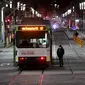 Orang-orang menyeberang jalan selama aturan jam malam di Melbourne, pada Selasa (17/8/2021). Kota terbesar kedua di Australia itu memberlakukan pembatasan tinggal di rumah pada pukul 9 malam hingga 5 pagi untuK meredam lonjakan Covid-19 varian Delta. (William WEST/AFP)