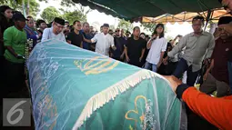 Presenter Farhan bersama keluarga mengikuti proses pemakaman anak pertamanya Muhammad Ridzky Khalid di TPU Tanah Kusir, Jakarta, Senin (21/12). Ridzky menghebuskan nafas terakhirnya akibat penyakit leukimia. (Liputan6.com/Immanuel Antonius)
